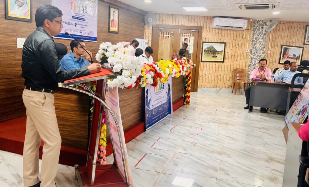 Rajeev Singh, Founder and Managing Director of Sansar Green, speaking behind a flower-decorated podium with TEJAS signage.